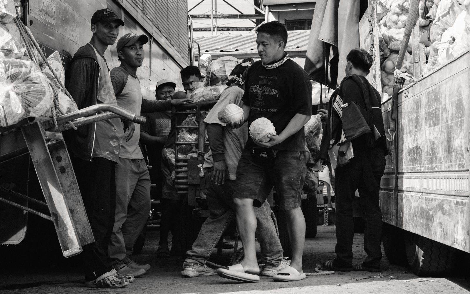 Porters working in a busy market, captured in black and white for a classic look.
