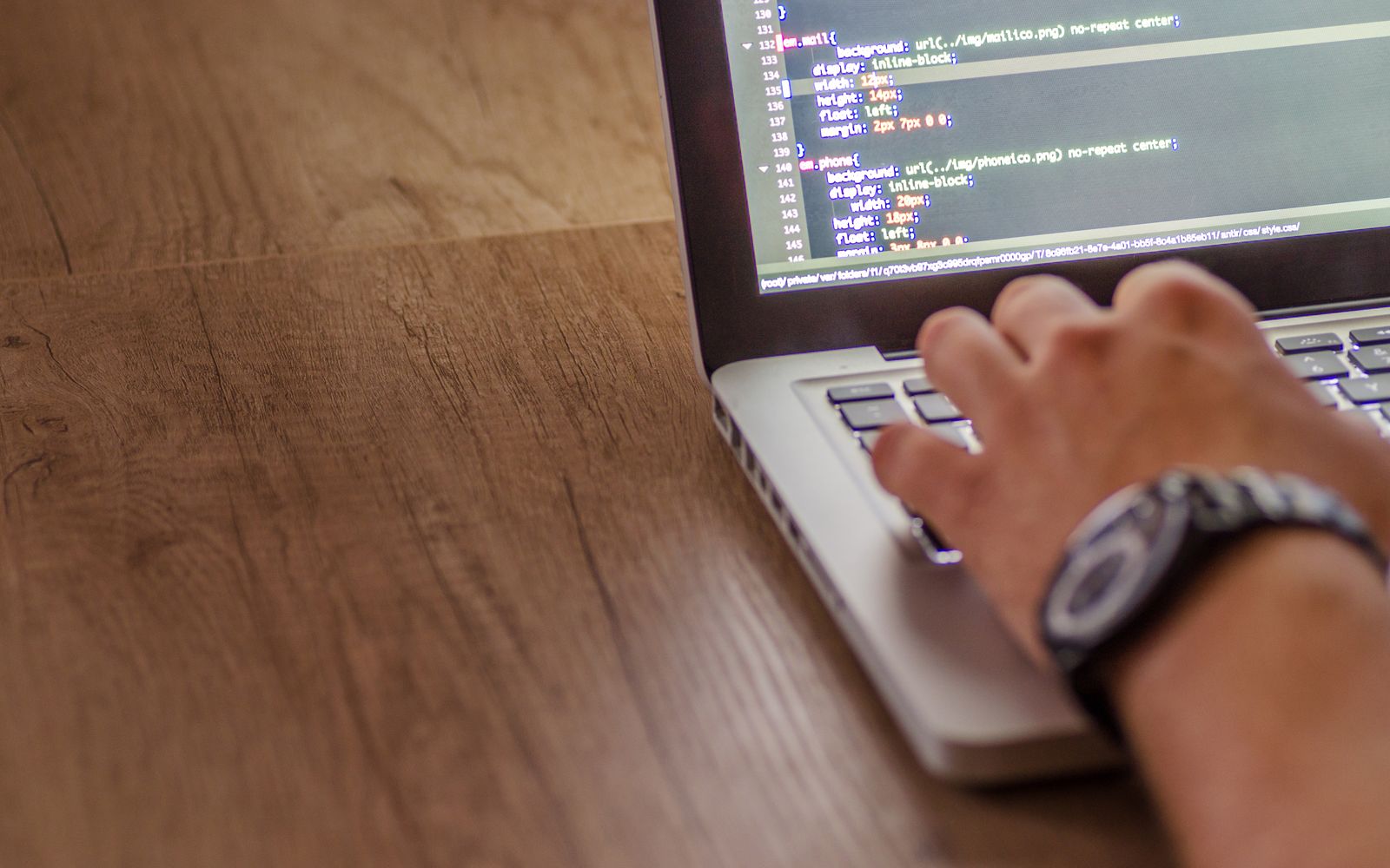 Close-up of a person coding on a laptop, showcasing web development and programming concepts.