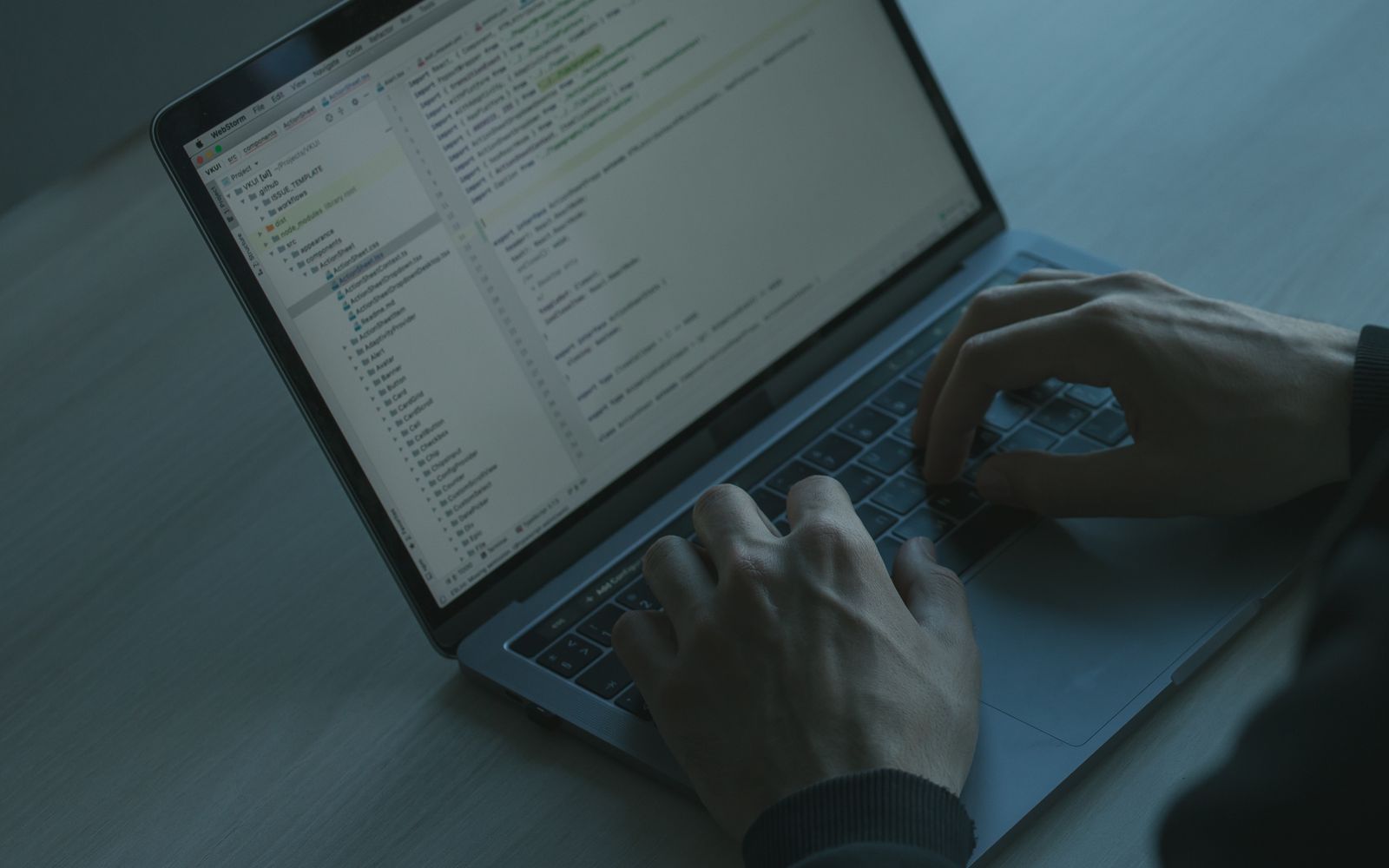 A person typing code on a laptop with a focus on cybersecurity and software development.
