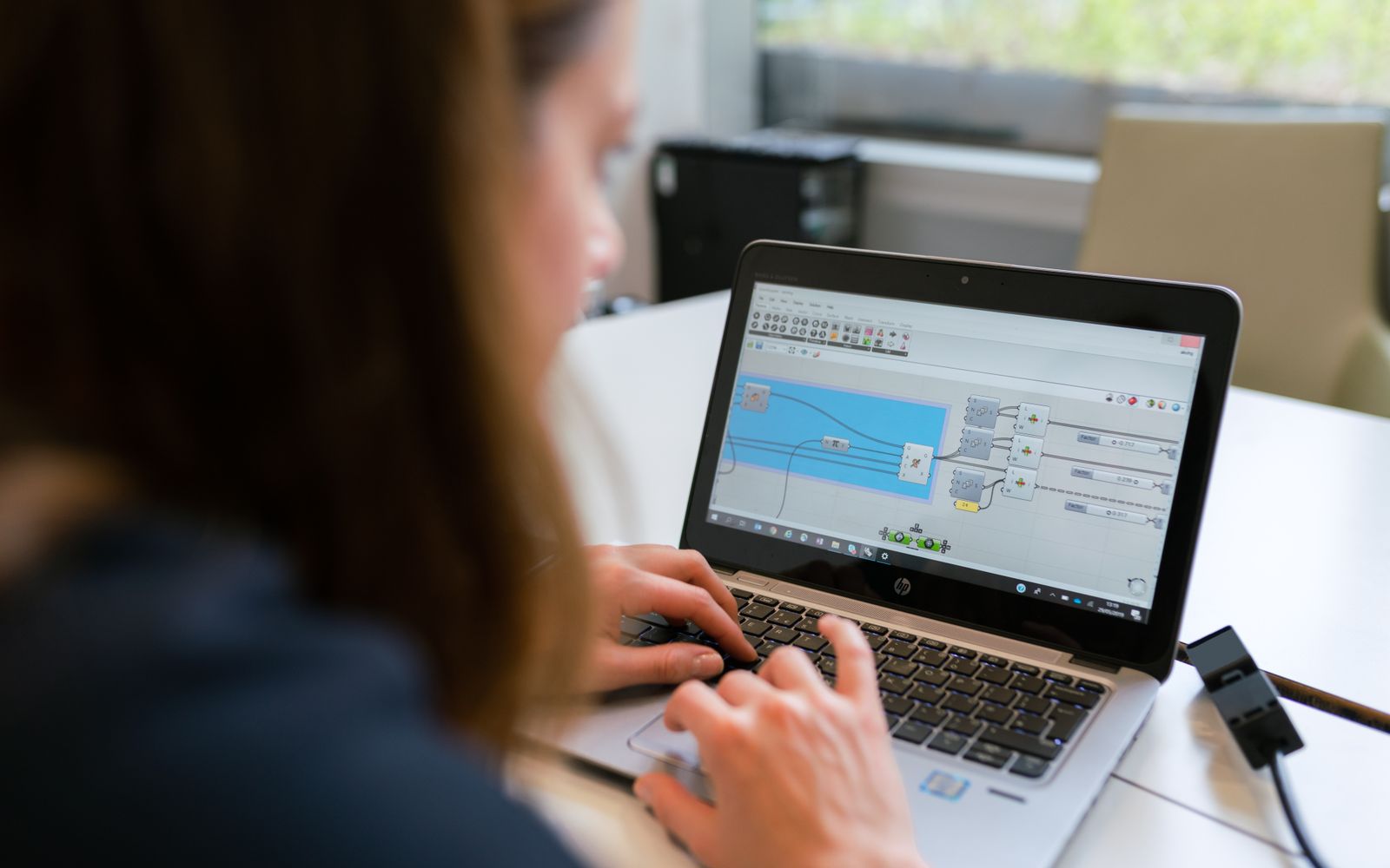 A woman engineer focuses on software analysis using a laptop indoors.