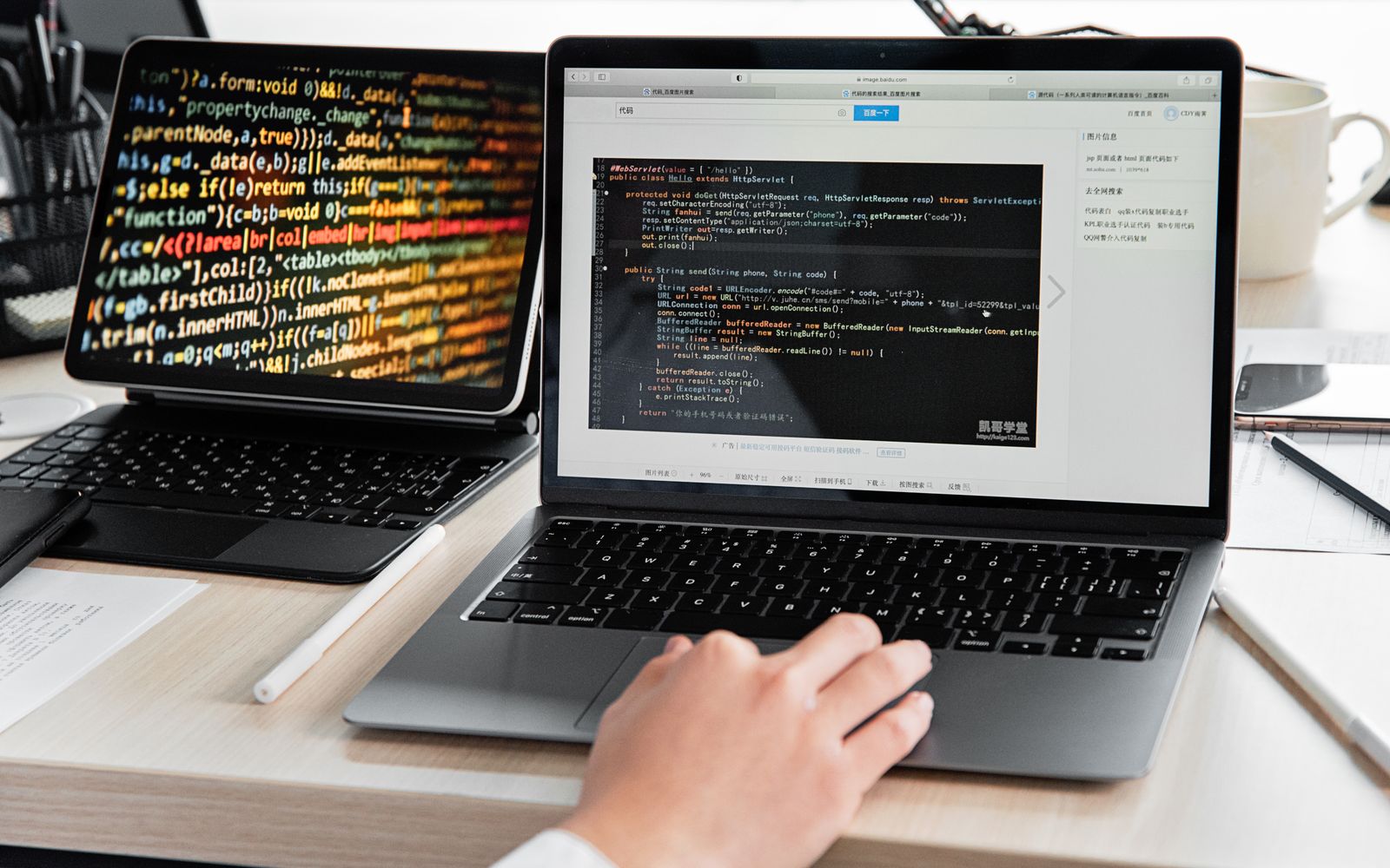 A developer writing code on a laptop, displaying programming scripts in an office environment.