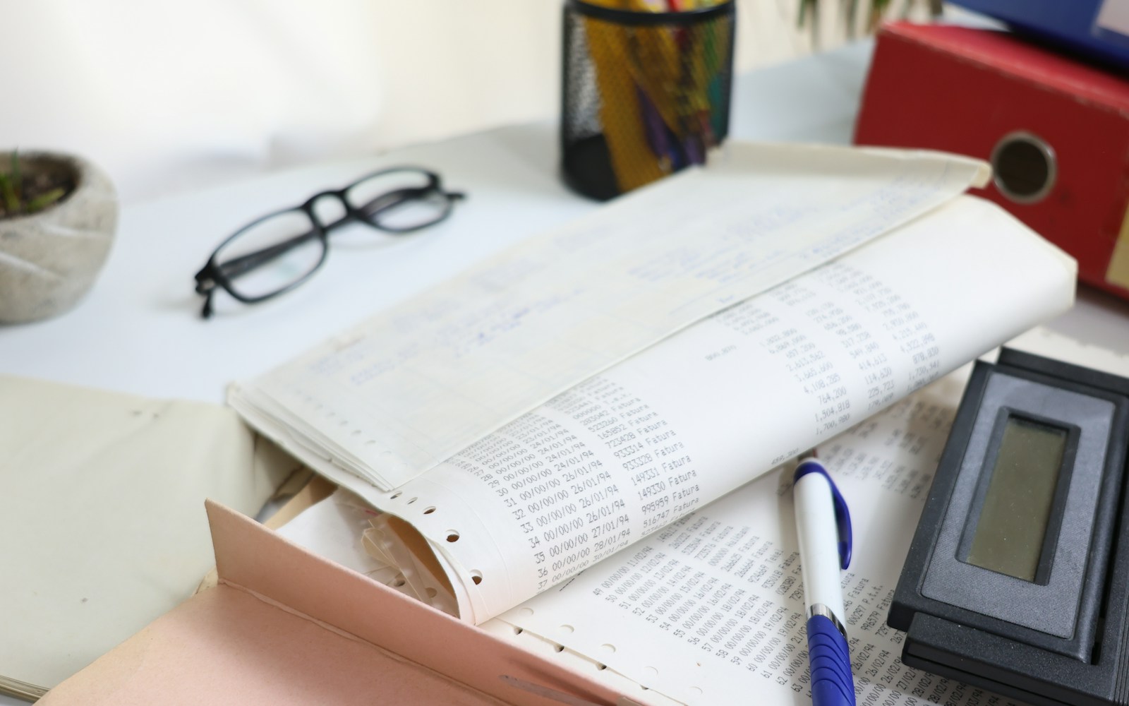 A desk with a calculator and planning documents for estimating project costs.