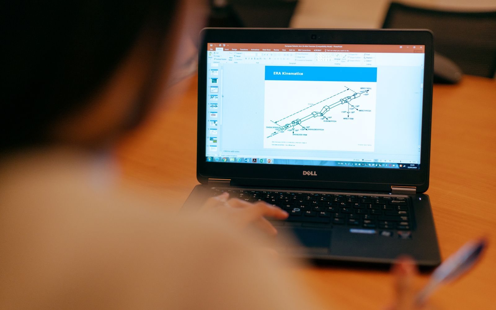 Female engineer working on laptop reviewing technical engineering presentation.
