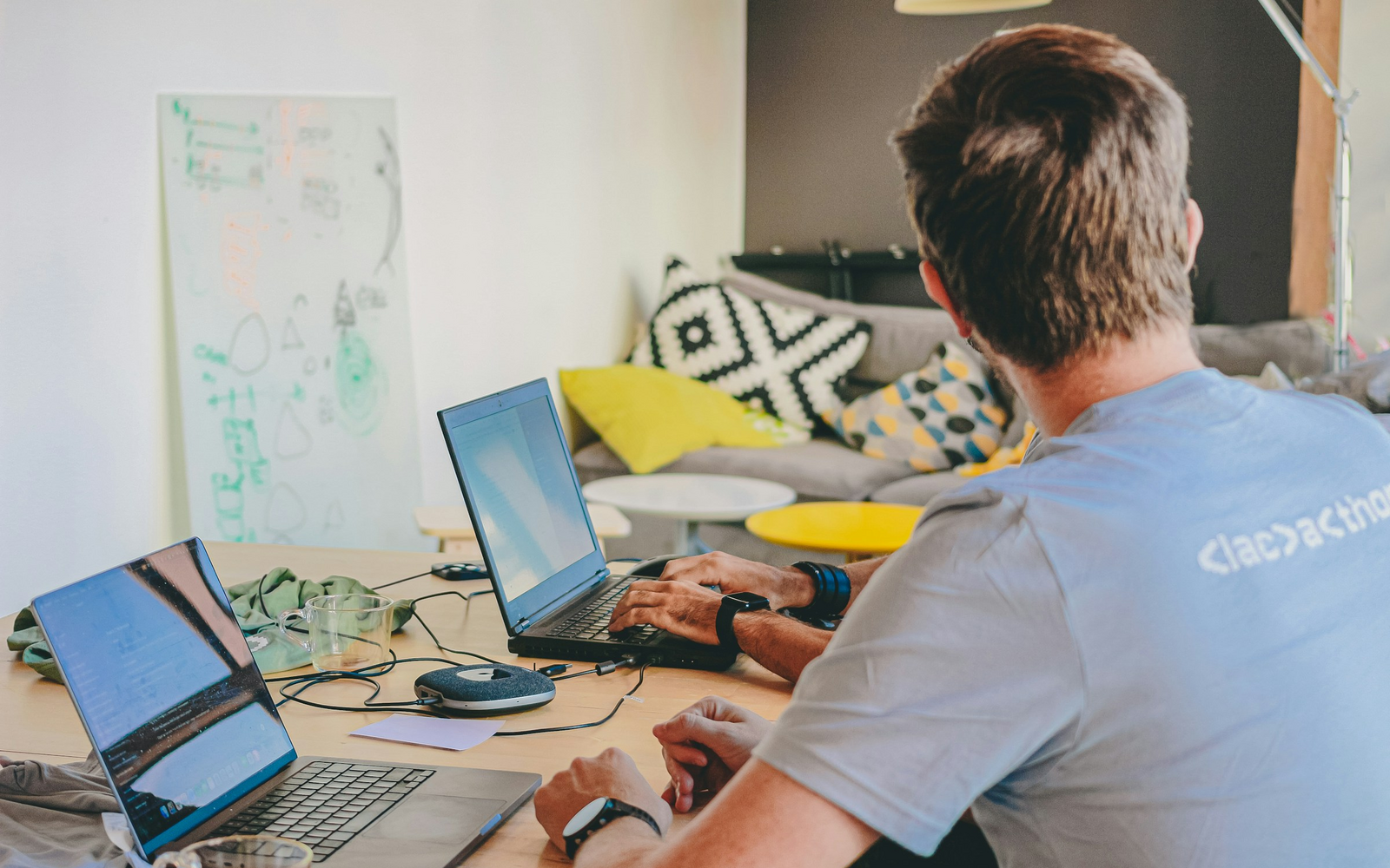 Developer working across multiple laptops in a shared engineering workspace