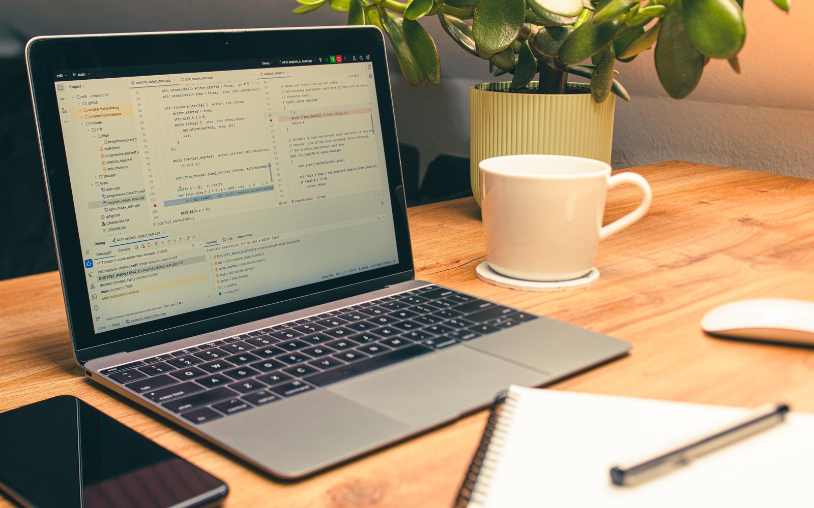 Cozy home office setup featuring a laptop, coffee, and a green plant for productivity.