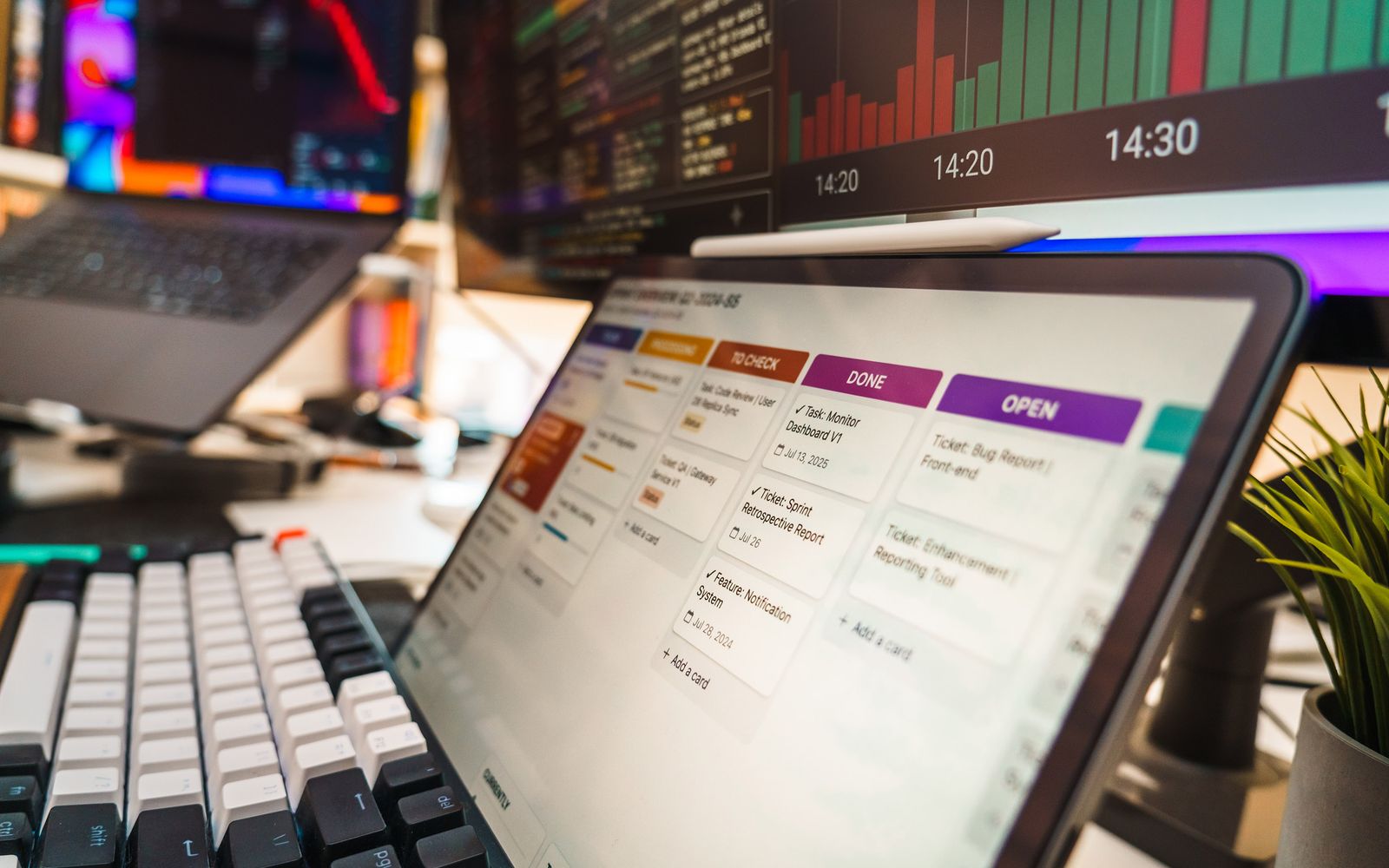 A dynamic office setup featuring multi-screen displays with data charts and project management tools, perfect for tech or business environments.