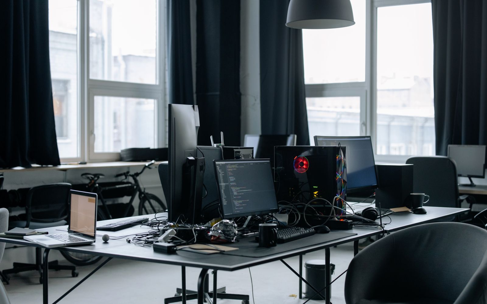 Contemporary workspace featuring computers, coding screens, and office essentials in a tech environment.