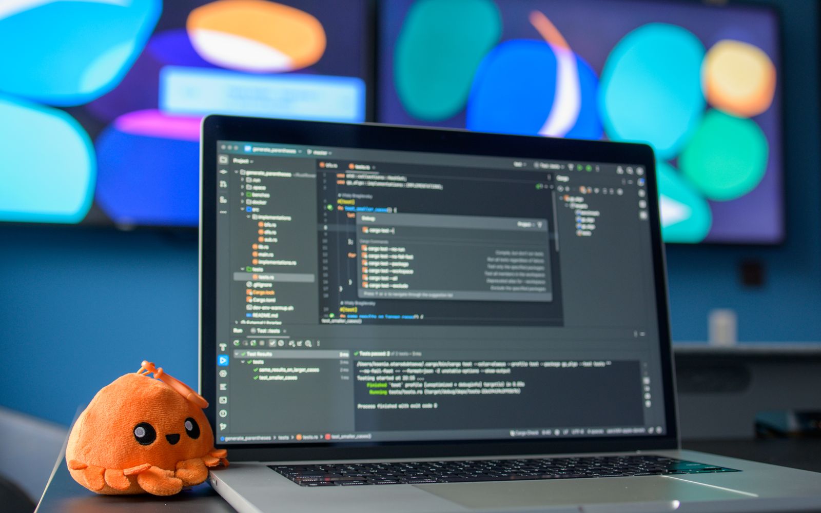Colorful workspace featuring a laptop with code editor and vibrant screens.